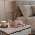 Heated Steam Eye Mask on bedside table with candle and skincare