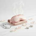Flat lay of Heated Steam Eye Mask with USB cable, remote, and rose petals on marble